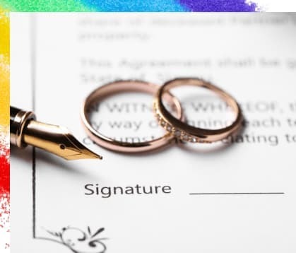 文書の署名欄の近くに結婚指輪とペンが置かれた画像で、婚姻の合意契約を表現している