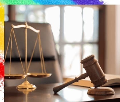 机の上のガベルと天秤に窓からの後光が差している画像で、同性カップルについて事実婚適用の幅が広がったことを示唆している