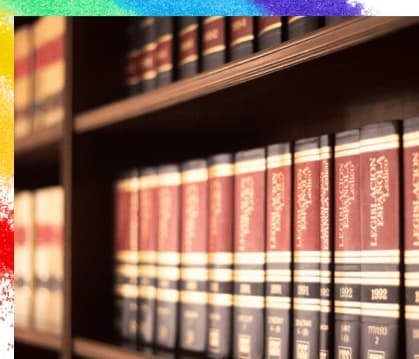 書棚に法律書と思われる分厚い本が並べられている画像で、同性事実婚に適用される33法令を暗示している